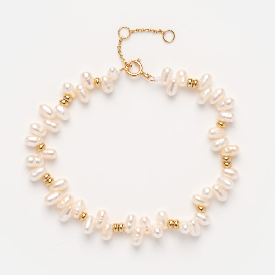 The Solid Gold Baroque Pearl Bracelet Sample features irregular white pearls with small gold beads on a 9k yellow gold chain and clasp with extender, displayed on a plain white background.