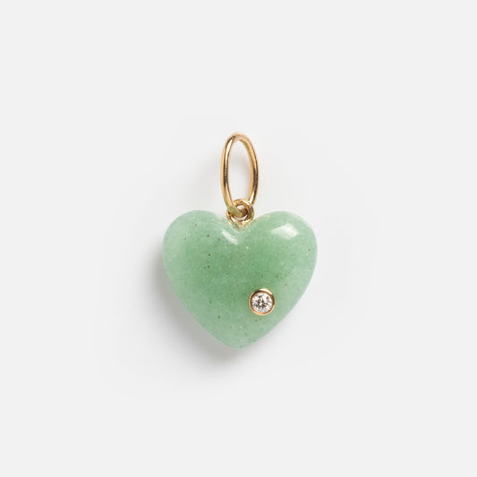 The Solid Gold Full Heart Crystal Charm features a heart-shaped green crystal pendant with a small gold loop and a clear diamond accent on the lower right, set against a white background.