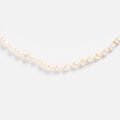 A close-up of the Freshwater Pearl Knotted Necklace, featuring white, oval-shaped pearls arranged in a gentle curve on a plain white background.