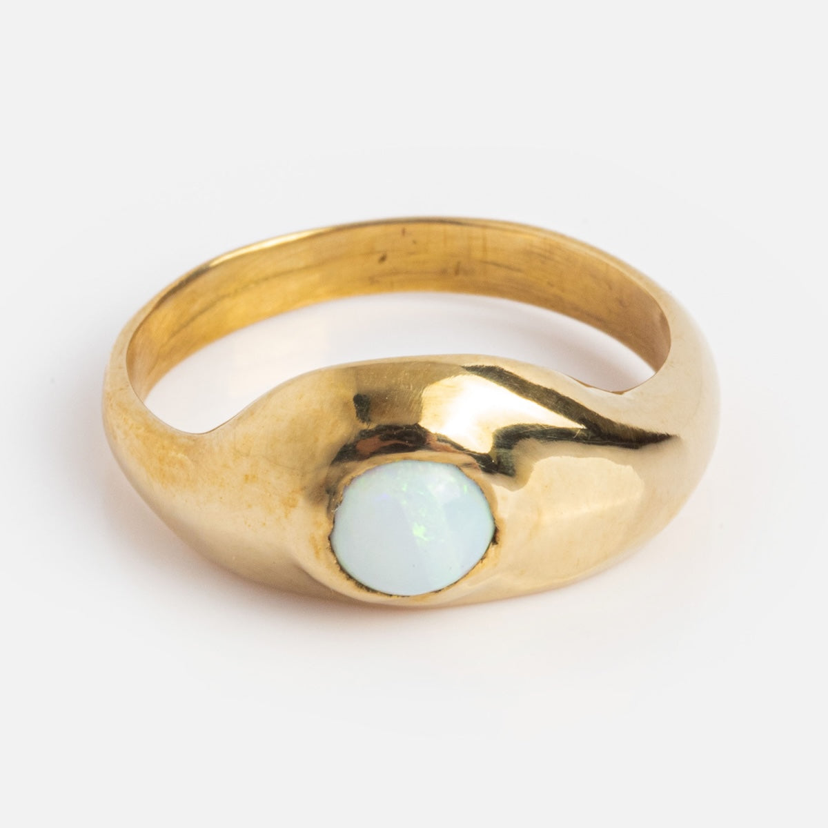 The Aether Opal Ring Sample Size 6 features a smooth recycled brass band and a 5 mm round white opal gemstone set at the center, shown against a plain white background.
