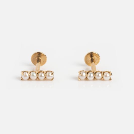 The Solid Gold Pearl Bar Flat Back Studs feature a horizontal row of four small white pearls on each earring, shown against a white background.
