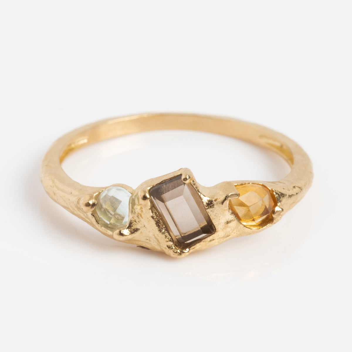 The Solid Gold Organic Woodland Ring Sample Size 7 showcases a rectangular smoky quartz center, flanked by a round pale green stone and a yellow gem, displayed on a plain white background.