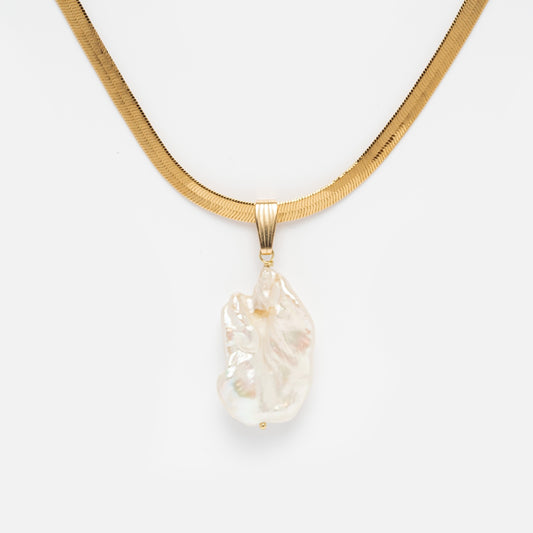 The Ciao Bella Necklace Sample features a gold filled flat, wide chain with a handmade, irregular baroque pearl pendant hanging at the center, displayed against a white background.