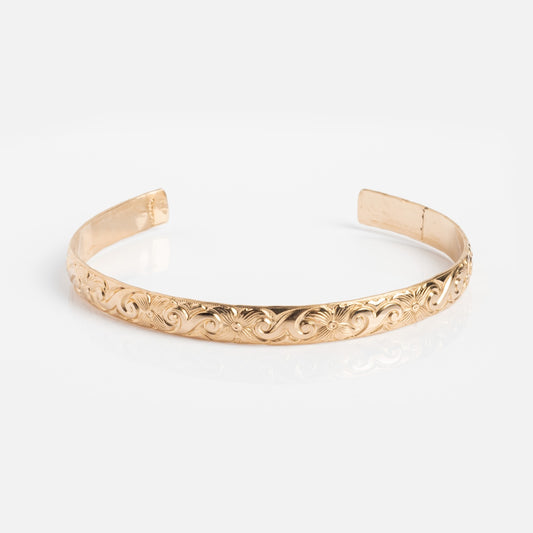The Goddess Cuff Sample, a gold filled bracelet with intricate floral and scroll engravings, handmade in Costa Mesa, is displayed on a white background.