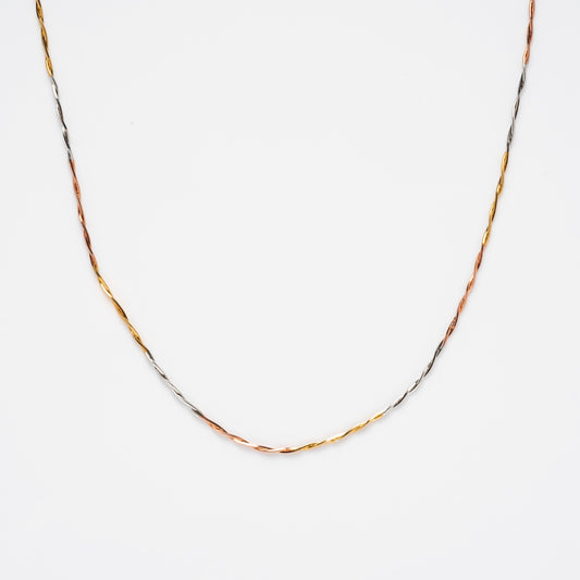 The Mixed Metal Twisted Chain features elegant silver, gold, and rose gold tones in a delicate twisted design, creating a stunning mixed metal look shown against a plain white background.