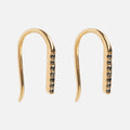The Solid Gold Black Diamond Open Ear Huggers are minimalist 9k gold earrings with a row of small black stones along the front, offering timeless elegance as subtle black diamond earrings, shown against a plain white background.
