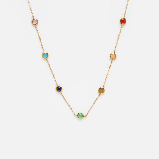 The Solid Gold Chakra Necklace Sample is a delicate 9k yellow gold chain with seven evenly spaced, bezel-set round natural gemstones in various colors.