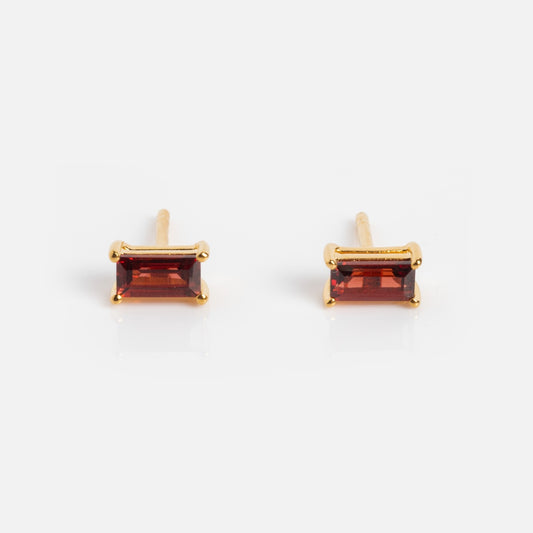The Birthstone Baguette Studs are yellow gold vermeil earrings with rectangular deep red gemstones in simple prongs, shown on a white background—an elegant choice for birthstone studs.