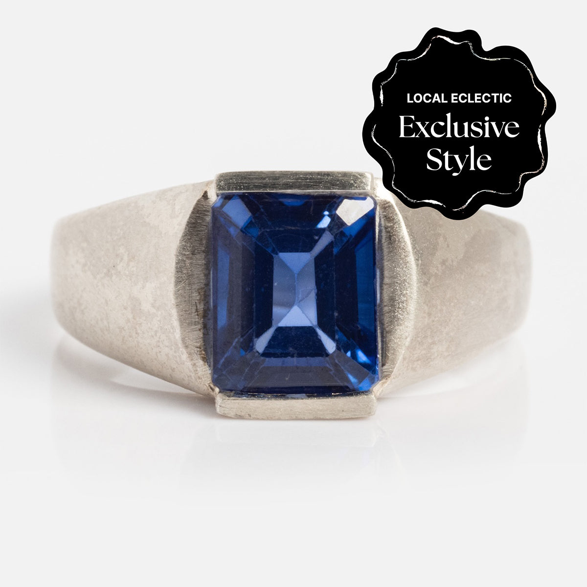 The Legacy Ring features a large, rectangular 8mm x 6.6mm lab-created blue sapphire center set in silver. A black label in the corner states Local Eclectic Exclusive Style.