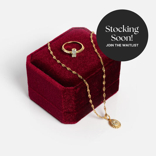 The 2026 March Aquamarine Capsule Set with Free Gift is displayed on a dark red velvet jewelry box. A circular label reads Stocking Soon! Join the waitlist for this beautiful March birthstone jewelry set.