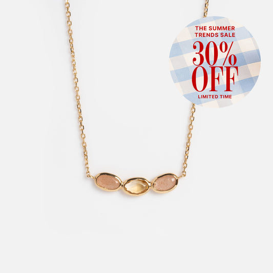 The Solid Gold Morning Light Citrine and Sunstone Necklace shines on a white background. A circular sticker at the top right reads, THE SUMMER TRENDS SALE 30% OFF LIMITED TIME, in red on a blue and white checkered pattern. Local Eclectic.