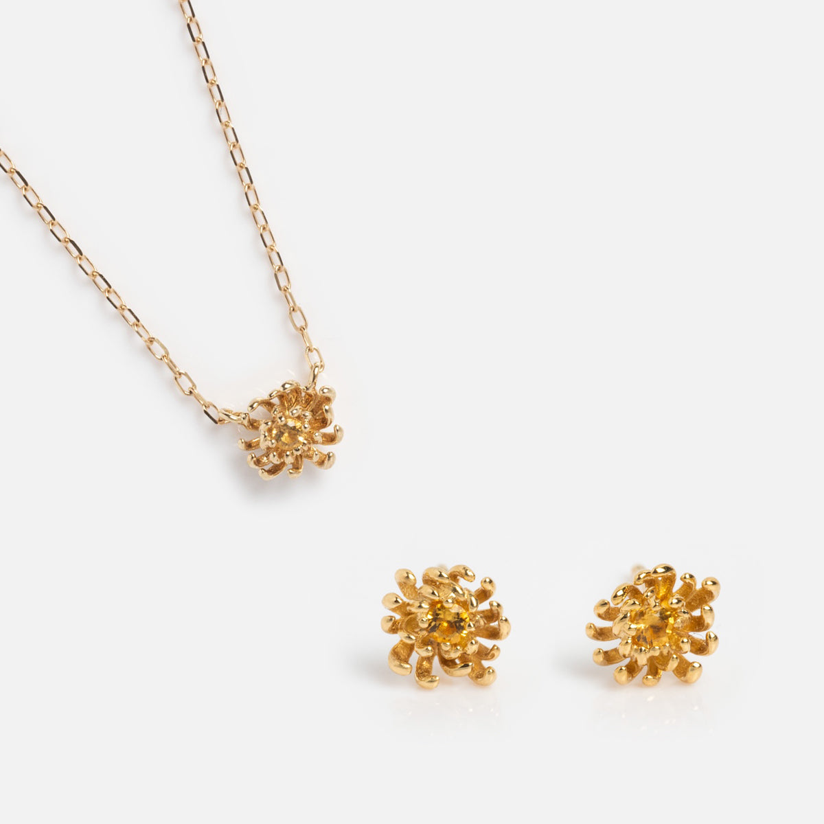 The Solid Gold Birth Flower Gift Set features a solid gold necklace and matching stud earrings, each with a textured flower cluster design—an elegant jewelry gift set shown on a white background.