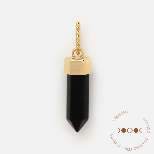 A faceted black obsidian pendant capped in gold with a gold loop: the Solid Gold Crystal Charm for Manifestation. Beside it, text reads: OBSIDIAN, CLARITY • SELF CONTROL • GROWTH with crescent moons—ideal for manifestation rituals.