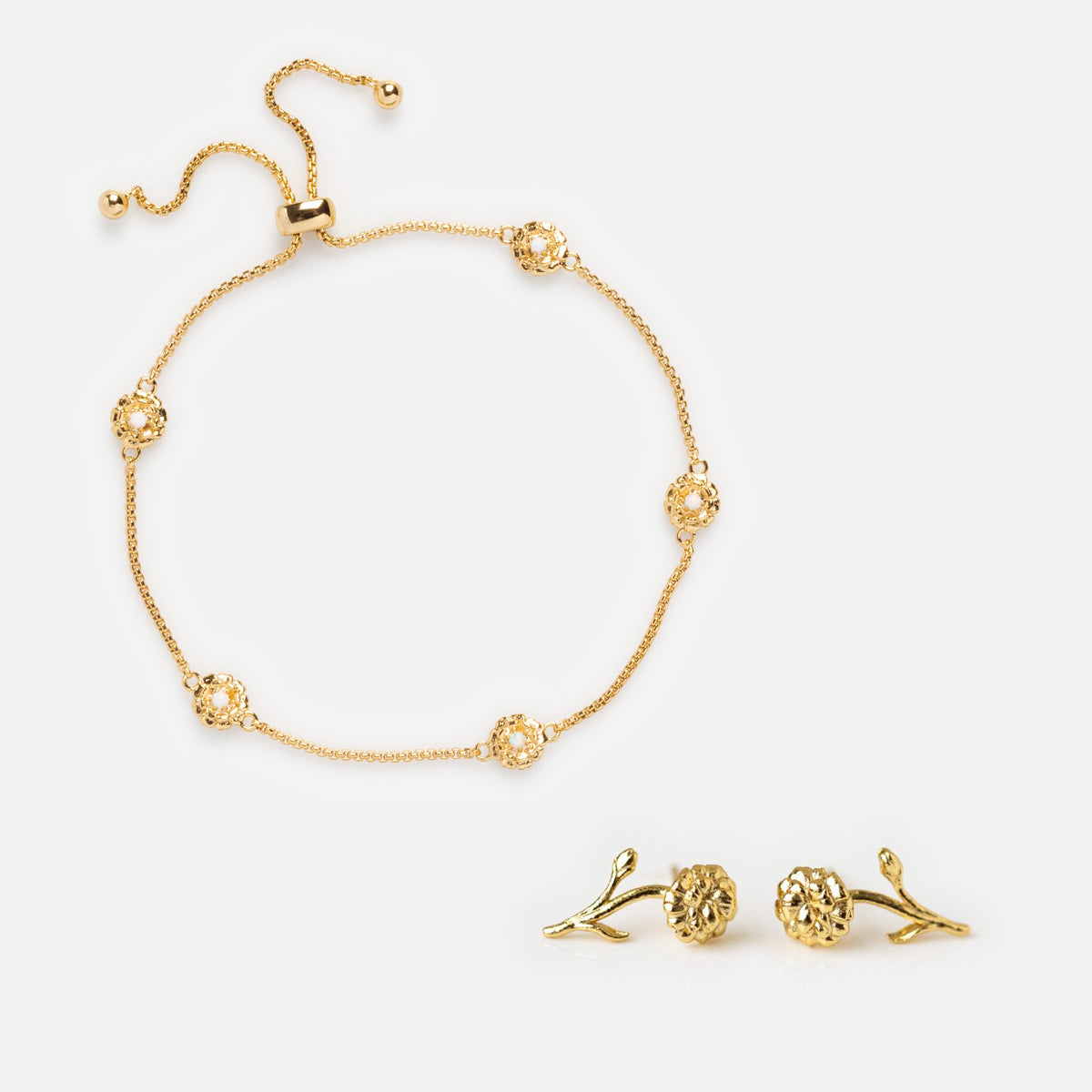 The Birth Flower Gift Set features a delicate bracelet with five flower-shaped charms and a sliding clasp, paired with blooming flower earrings accented by small branches—an elegant, charming gift.