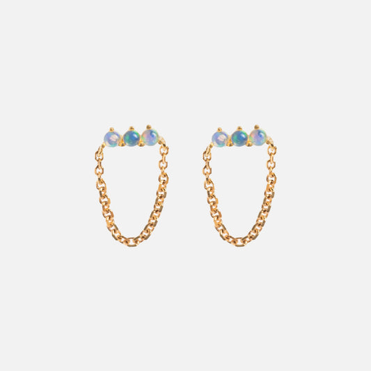 The Solid Gold Opal Trio Chain Dangle Studs feature three Ethiopian opals atop each stud, linked by a delicate solid gold chain in a semicircle, shown against a plain white background.