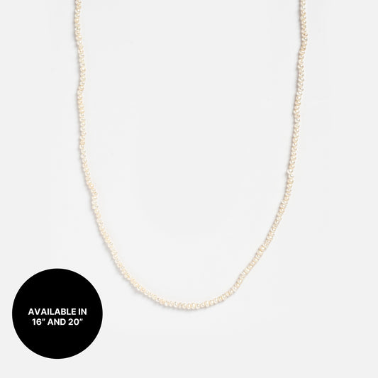 Chain For Charms necklace with delicate pearl beads shown on a plain white background. A black circle at the bottom left says AVAILABLE IN 16 AND 20 in white. Perfect for layering with other necklace chains.