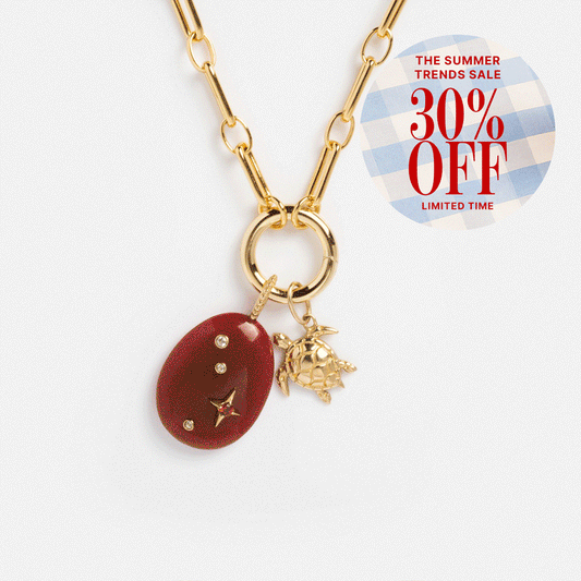 The Perfect Start Charm Holder Necklace features a gold-plated chain, turtle and red oval crystal charms, and charm clips. A badge at the top right says: “The Summer Trends Sale, 30% OFF, Limited Time.”.