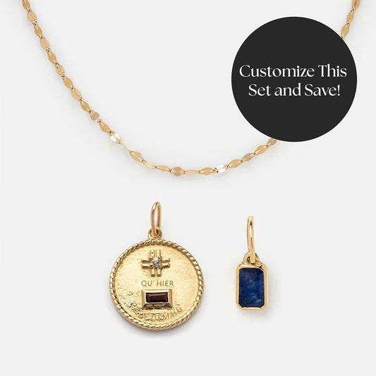 Solid Gold Personalized Gift Set: Gold chain necklace with a QuHier Que Demain Charm and Birthstone Baguette Charm. Features a round engraved gold pendant and a blue stone charm. Customize this unique solid gold gift set and save!.