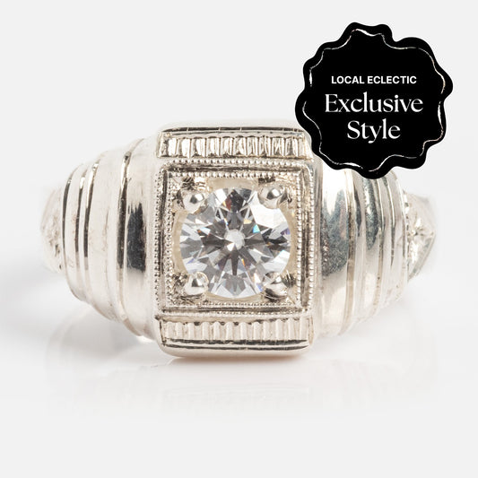 The Sacred Ring features a large round 0.42ctw moissanite set in a square bezel on a 3.7mm wide silver band with engraved details. A black badge with white text displays: Local Eclectic Exclusive Style.