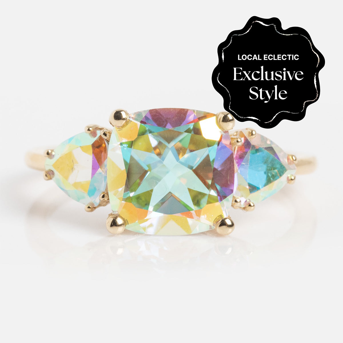 The Seraphina Ring features a gold band with a center of iridescent, multi-colored gemstones. A black badge in the upper right corner reads "Local Eclectic Exclusive Style.