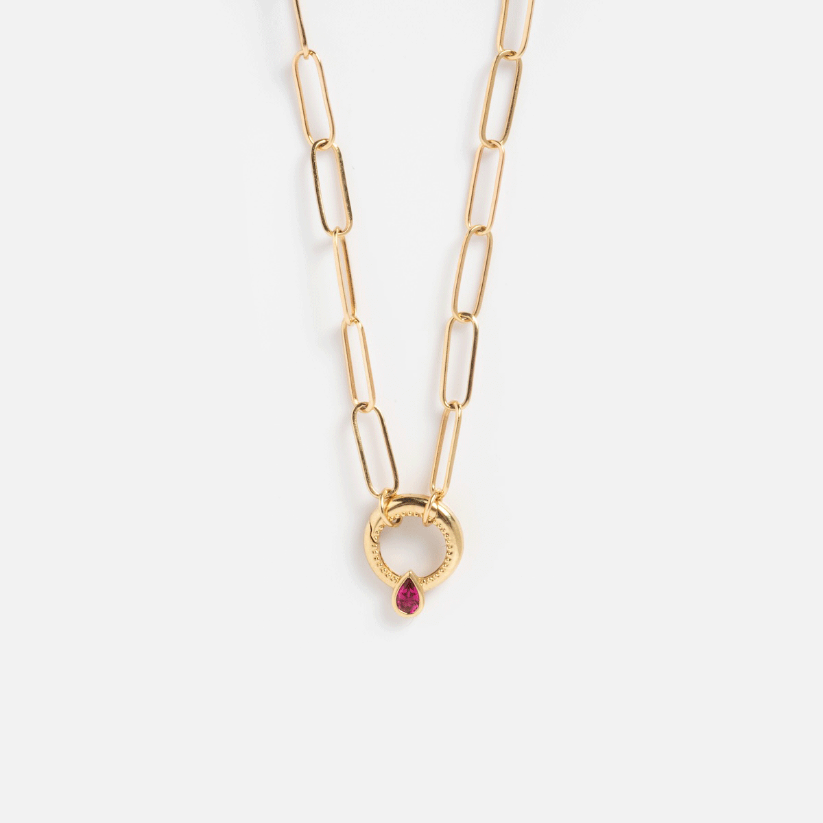 The Solid Gold Perfect Start Charm Holder Necklace features elongated links and a round, textured pendant with a central teardrop-shaped red gemstone.