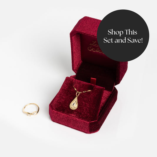 The Solid Gold 2026 April White Topaz Capsule Set with Free Gift includes a gold ring with white topaz and a teardrop pendant necklace in a red velvet box. Shop this set and save!.