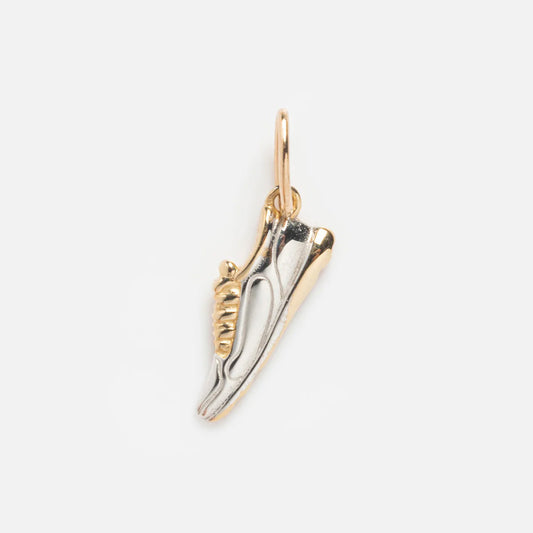 The Solid Gold Celebration Charm is a small sneaker-shaped charm with a gold loop, featuring a two-tone silver and 9k solid yellow gold design, shown on a light gray background.