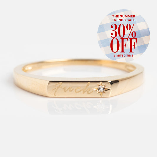 The Solid Gold Tiny Fuck Ring features a bold engraving and a delicate diamond star detail, plus enjoy The Summer Trends Sale—30% OFF for a limited time!.