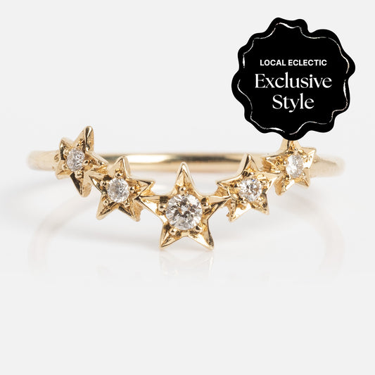 The Stars Aligned Band features five star-shaped gold settings, each with a sparkling diamond totaling 0.10 ctw in a graceful curve. A black badge in the top right corner reads "Local Eclectic Exclusive Style.