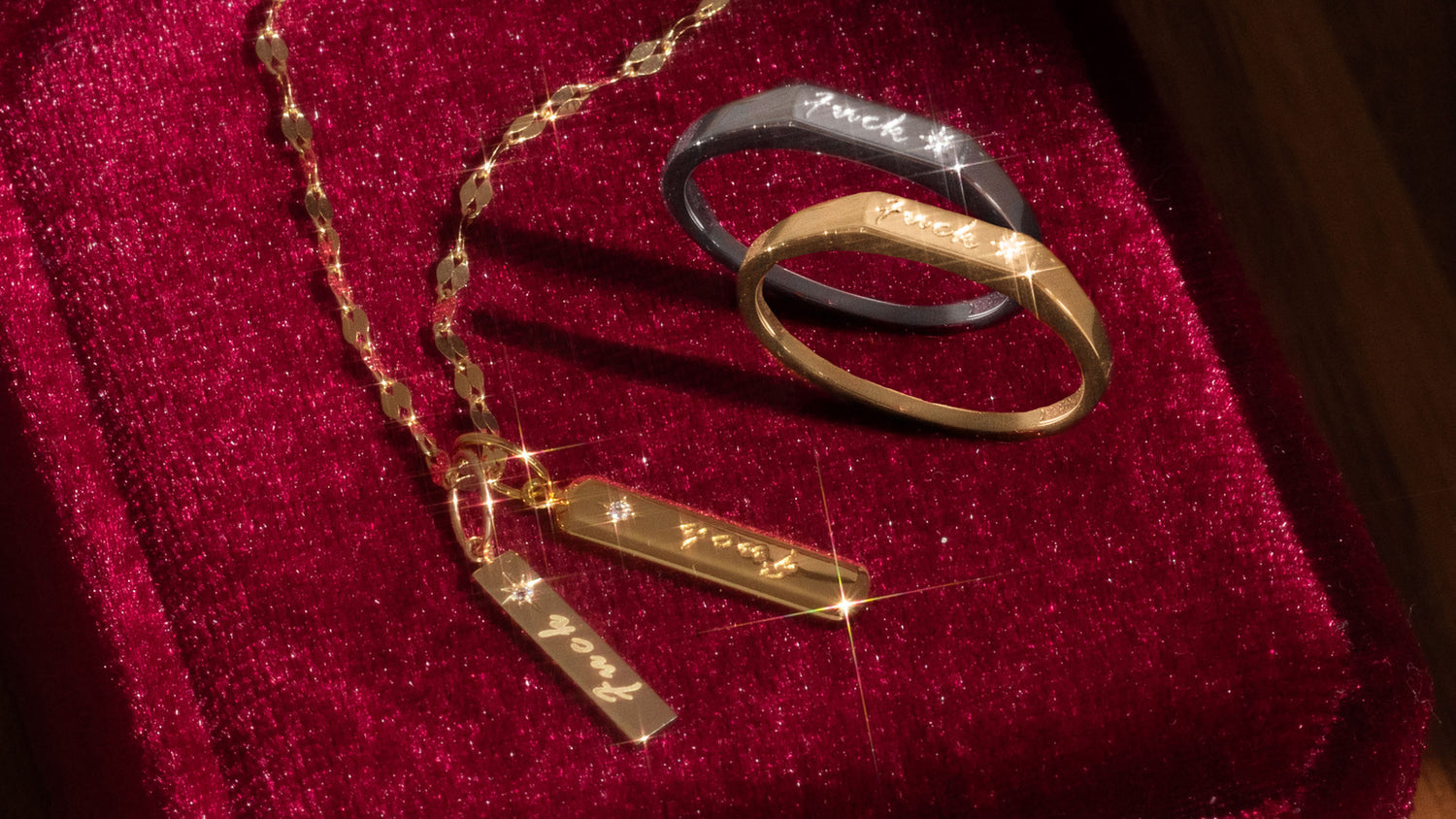 Gold and silver rings with engraved text on a red velvet surface