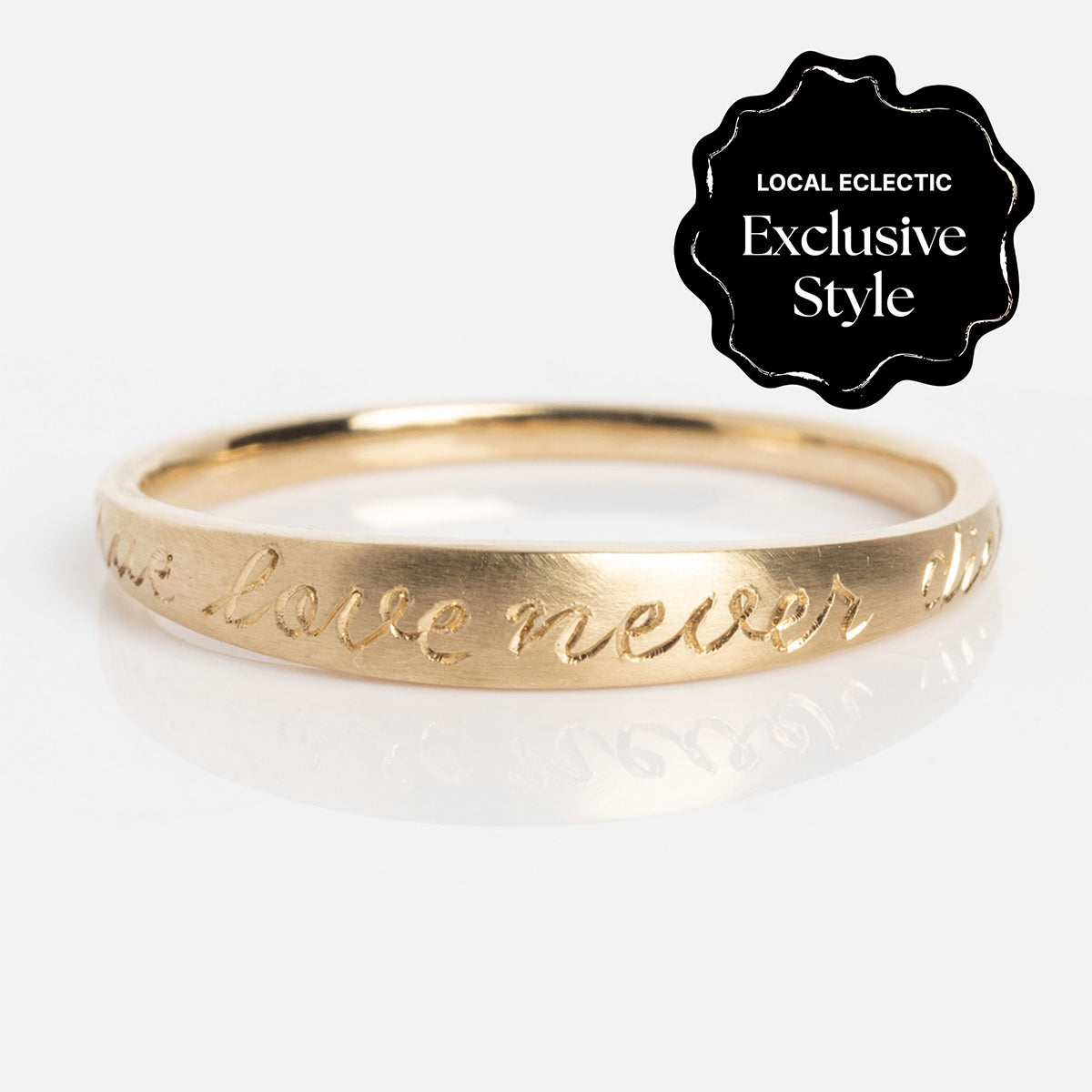 The True Love Never Dies Band, a thin gold ring with a 1.2 mm band and engraved script text, is displayed on a white background. A black badge at the top right reads Local Eclectic Exclusive Style.