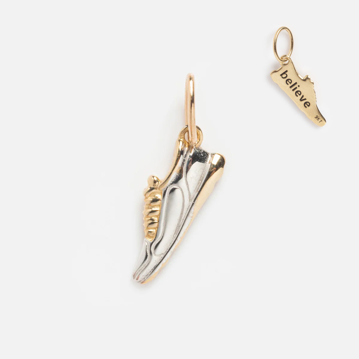 A two-tone sneaker-shaped charm with silver and gold details sits beside the Solid Gold Celebration Charm, engraved with "believe" and shaped like a state.