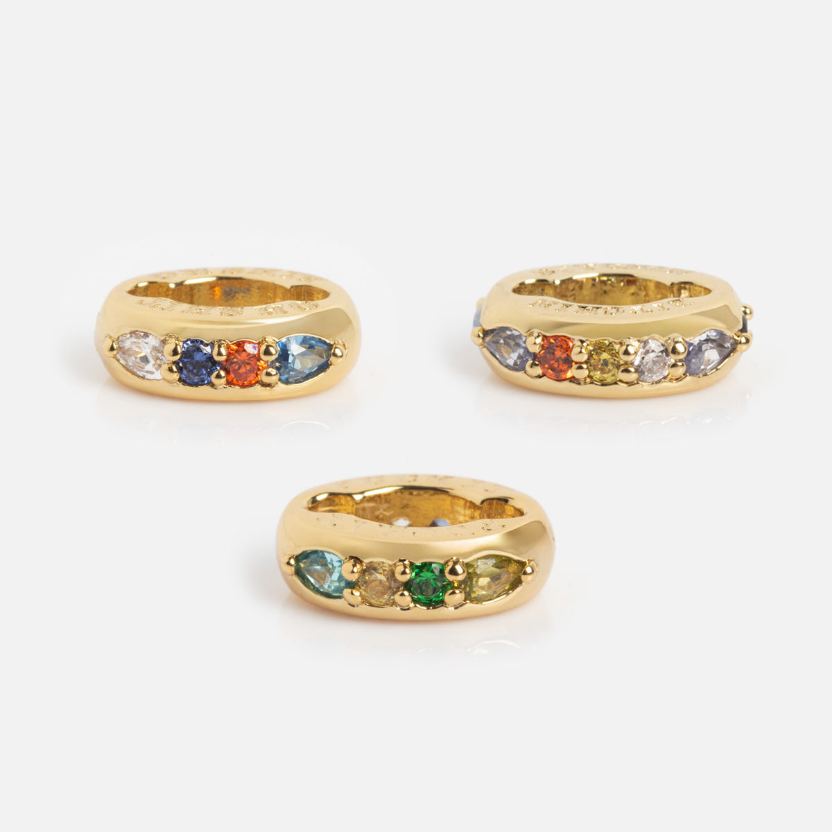 Three Hidden Curse Word Spacer Charms, each adorned with colorful gemstones in various shades, are displayed against a plain white background.