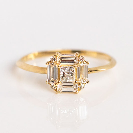 The 14k Vintage Inspired Lab Diamond Art Deco Engagement Ring, Sample Size 9, is crafted in recycled yellow gold with a square cluster of baguette and round lab-created diamonds and a central princess-cut diamond, shown on a white background.