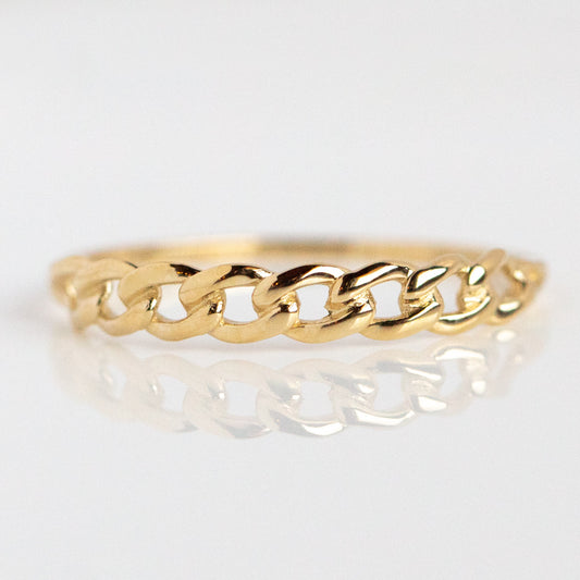 The Solid Gold Chain Link Ring features a delicate, unique design. Shown against a white background with a subtle reflection, this gold band highlights the elegance of its chain link style.