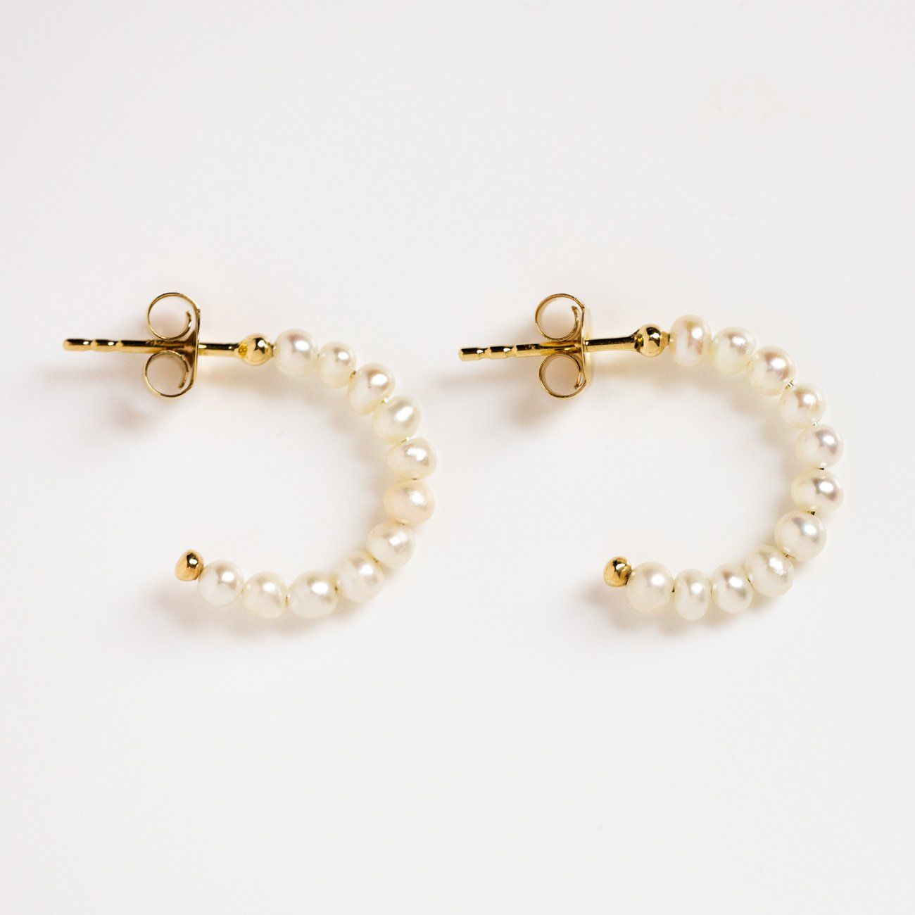 solid gold simple pearl huggie hoop earrings dainty minimal modern fine jewelry\