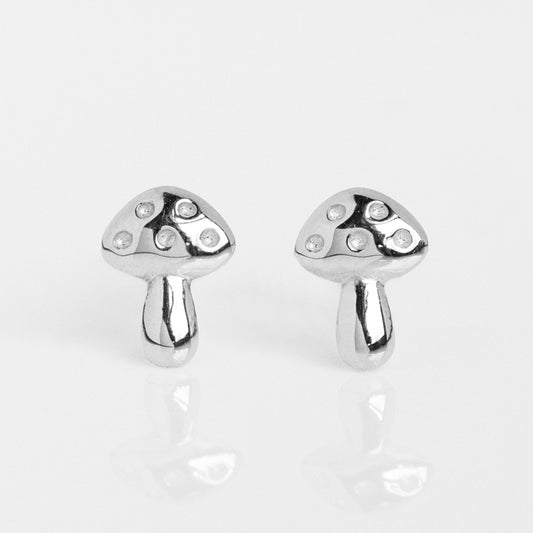 A pair of Solid Gold Mushroom Studs, each featuring three small circular details on the cap, displayed on a reflective white surface.