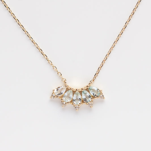 A 9k solid yellow gold Ombre Birthstone Necklace (March Sample) features a fan-shaped pendant with five marquise-cut light blue gems and small round diamond accents, shown against a white background.