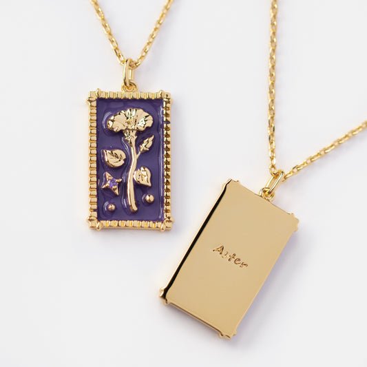 Two gold rectangular Enamel Birth Flower Pendant Necklaces: one with a raised flower on purple enamel, the other engraved Aster with a plain gold side. Both feature decorative frame edges and hang from chains.