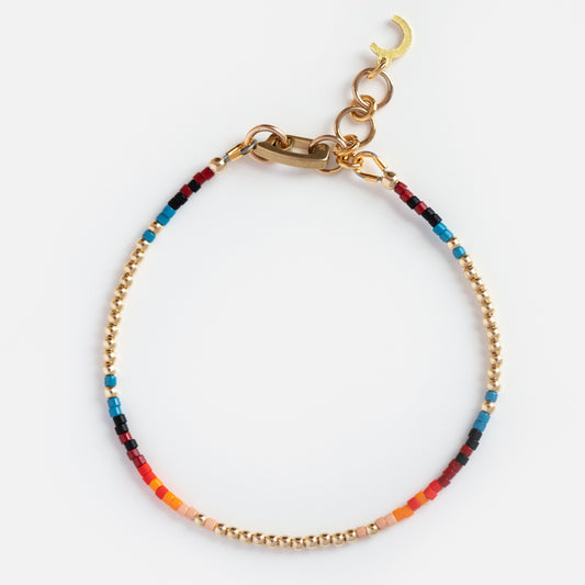 The Single Serpent Beaded Bracelet features small gold and Miyuki beads in red, blue, orange, pink, and black sections, finished with a 14k gold filled chain clasp and crescent moon charm.