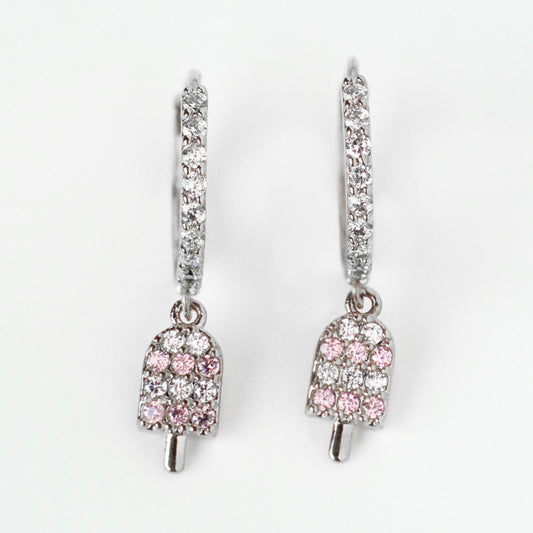 The Ice Cream Hoop Earrings Silver Sample features rhodium plated silver hoops set with clear cubic zirconia and a dangling popsicle charm adorned with pink and clear gemstones.